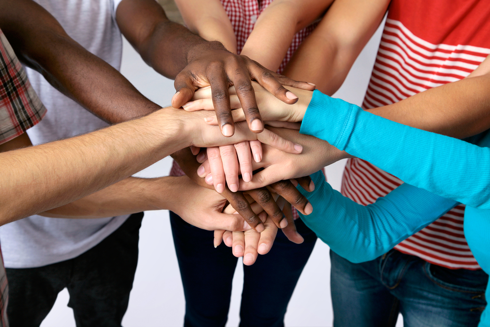 Team of friends showing unity with their hands together